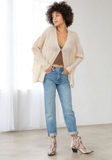 [Color: Oatmeal] A front facing image of a brunette model wearing a knit and lace beige cardigan with a hook and eye closure, batwing sleeves, and slim sleeve finish. A cozy and effortless cardigan for the fall season. 