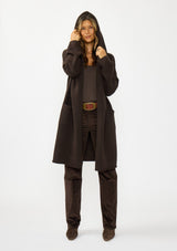 [Color: Chocolate] A front facing image of a brunette model wearing a best selling brown oversized cardigan. A cozy and thick sweater coat with a hood, an open front, side pockets, a cocoon style silhouette, and a mid length hem. 