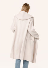 [Color: Oyster] A back facing image of a blonde model wearing a best selling oversized light grey cardigan. A cozy and thick sweater coat with a hood, an open front, side pockets, a cocoon style silhouette, and a mid length hem.
