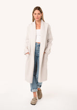 [Color: Oyster] A full body front facing image of a blonde model wearing a best selling oversized light grey cardigan. A cozy and thick sweater coat with a hood, an open front, side pockets, a cocoon style silhouette, and a mid length hem.