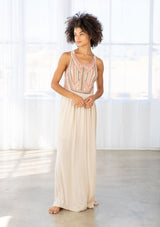 [Color: Natural/Olive/Coral] A front facing image of a brunette model wearing a beige sleeveless maxi dress with a coral embroidered bodice and a scoop neckline. 