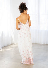 [Color: Blue Rose/Vanilla] A back facing image of a brunette model wearing a bohemian white and pink butterfly print maxi dress with a v neckline and adjustable spaghetti straps. 