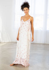 [Color: Blue Rose/Vanilla] A front facing image of a brunette model wearing a bohemian white and pink butterfly print maxi dress with a v neckline and adjustable spaghetti straps. 