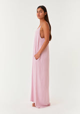[Color: Orchid] A side facing image of a brunette model wearing an orchid purple sleeveless maxi dress with gold metallic thread details. With adjustable spaghetti straps, a deep v neckline in the front and back, side pockets, and a loose, oversized flowy fit. 