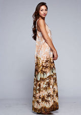 [Color: Peach] A side facing image of a brunette model wearing a tropical print maxi dress with a relaxed fit, v neckline, and adjustable spaghetti straps. 
