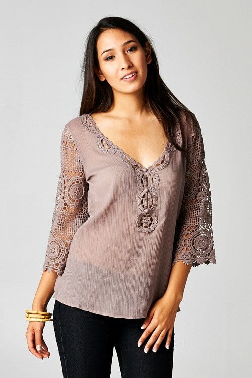 [Color: Dusty Orchid] A front facing image of a brunette model wearing a 3-4 sleeve cotton blouse with delicate crochet lace details. 