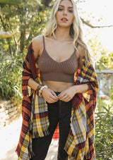 [Color: Brown] A blonde model wearing a rib knit crop top in brown. Featuring a v neckline, spaghetti straps, and a body hugging silhouette. A soft and cozy top crafted in stretchy fabric, perfect for layering or wearing on its own. 