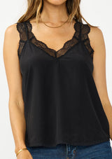 [Color: Black] A detail image of a brunette model wearing our beloved lace trim camisole, now reimagined with elegant lace-trimmed straps and a sophisticated lace V-neckline. This versatile piece features a flattering racerback design with delicate pretty lace straps, making it the perfect layering essential.