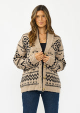 [Color: Taupe/Black] A front facing image of a brunette model wearing a brown and black button front cardigan with a southwestern pattern. 