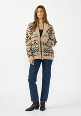 [Color: Taupe/Black] A front facing image of a brunette model wearing a brown and black button front cardigan with a southwestern pattern. 