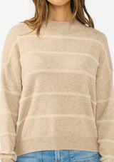 [Color: Heather Taupe] A detail image of a brunette model wearing a brown striped pullover sweater with a striped design and a high neckline. 