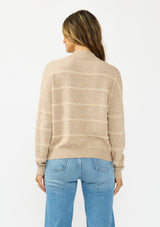 [Color: Heather Taupe] A back facing image of a brunette model wearing a brown striped pullover sweater with a striped design and a high neckline. 
