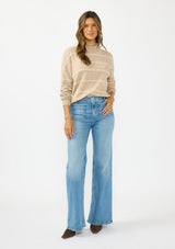 [Color: Heather Taupe] A front facing image of a brunette model wearing a brown striped pullover sweater with a striped design and a high neckline. Styled  with brown suede boots. 