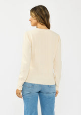 [Color: Peach] A back facing image f a brunette model wearing a cream fuzzy pullover sweater with a v neckline, button front, and long sleeves. 