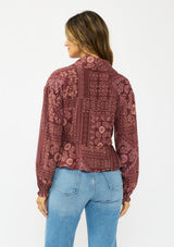 [Color: Wine/Dusty Rose] A back facing image of a brunette model wearing a bohemian burgundy floral tie front top with a deep v neckline and long sleeves. 