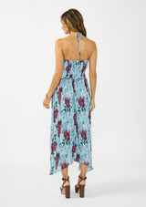 [Color: Blue/ Burgundy] A back facing image of a brunette model wearing a blue and burgundy floral plisse midi dress with a halter neckline and a shirred bodice.  