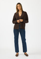 [Color: Brown] A front facing image of a brunette model wearing a brown open front cardigan with sequins and rib trims. 