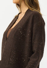[Color: Brown] A detail image of a brunette model wearing a brown open front cardigan with sequins and rib trims. 