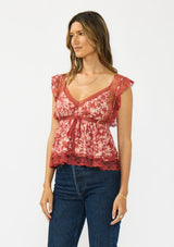 [Color: Wine/Dusty Rose] A side facing image of a brunette model wearing a wine floral print lace top with cap sleeves, v neckline, and a back button closure. 
