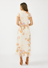 [Color: Ivory/Rust] A back facing image of a brunette model wearing a floral maxi dress with short flutter sleeves, a ruffled v neckline, button front, and a front slit. Styled with brown platform heels. 