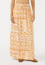 [Color: Taupe/Natural] A front facing image of a brown floral bohemian maxi skirt with a smocked waist and side slits. 