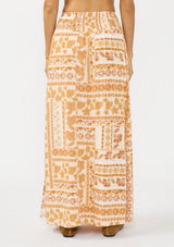 [Color: Taupe/Natural] A back facing image of a brown floral bohemian maxi skirt with a smocked waist and side slits. 