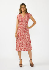 [Color: Wine/Dusty Rose] A front facing image of a brunette model wearing a wine floral print midi dress with a ruched bodice, v neckline, and short flutter sleeves. 