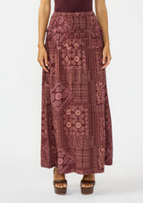 [Color: Wine/Dusty Rose] A front facing image of a brunette model wearing a bohemian burgundy floral skirt with drawstrings, styled with brown block heels. 