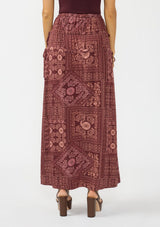 [Color: Wine/Dusty Rose] A back facing image of a brunette model wearing a bohemian burgundy floral skirt with drawstrings, styled with brown block heels. 
