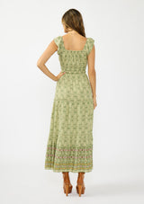 [Color: Olive/Rose] A back facing image of a brunette model wearing a green bohemian floral maxi dress with cap sleeves, a square neckline, elastic waist, and a tiered skirt with ruffle trims.