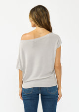 [Color: Light Heather Grey] A back facing image a brunette model wearing an off the shoulder sweater top with short sleeves and a fitted ribbed hem. 