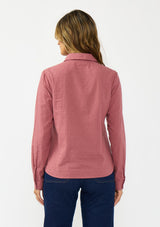 [Color: Rose] A back facing image of a brunette model wearing a pink shirt with a classic collar and button front. Styled with a dark wash denim with patch pockets. 