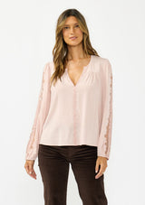 [Color: Shell] A front facing image of a brunette model wearing a pink embroidered top with mesh detail. Styled with a dark brown corduroy. 