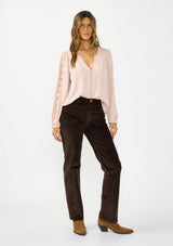 [Color: Shell] A front facing image of a brunette model wearing a pink embroidered top with mesh detail, tucked into a  dark brown corduroy with camel boots.