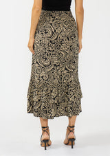 [Color: Black/Natural] A back facing image of a model wearing a tan and lack boho paisley skirt with a tiered ruffle hem. Styled with black strappy heels. 