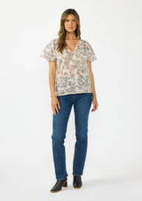 [Color: Cream/Black] A front facing image of a brunette model wearing a cotton floral top with double flutter sleeves and a split v neckline. 