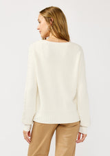 [Color: White] A back facing image of a blonde model wearing a white cozy rib stitch cardigan with a button front, v-neckline, ribbed border, and cable knit detailing along the sleeves. 
