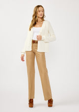 [Color: White] A front facing image of a blonde model wearing a white cozy rib stitch cardigan with a button front, v-neckline, ribbed border, and cable knit detailing along the sleeves. 