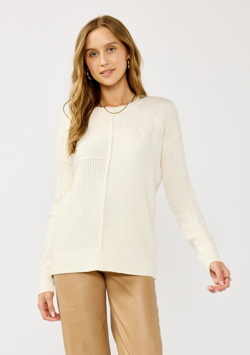 [Color: Cloud] A front facing image of a blonde model wearing a white cozy mix knit pullover sweater with a classic crew neckline. Lightweight and warm for casual outings or the office. 