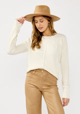 [Color: Cloud] A front facing image of a blonde model wearing a white cozy mix knit pullover sweater with a classic crew neckline. Lightweight and warm for casual outings or the office. 