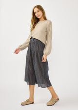 [Color: Navy/Taupe] A side facing image of a blonde model wearing a navy gingham skit with a button front and a smocked elastic waist at the back. A boho fall skirt paired with a sweater for the fall season. 