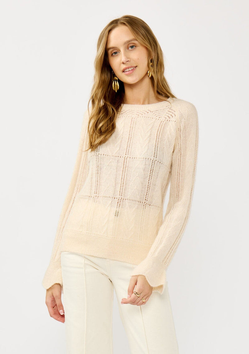 [Color: Blush] A front facing image of a blonde model wearing a fuzzy open knit pullover sweater with a crew neckline, long sleeves, and a flutter cuff. Lightweight and breezy for the fall season. 