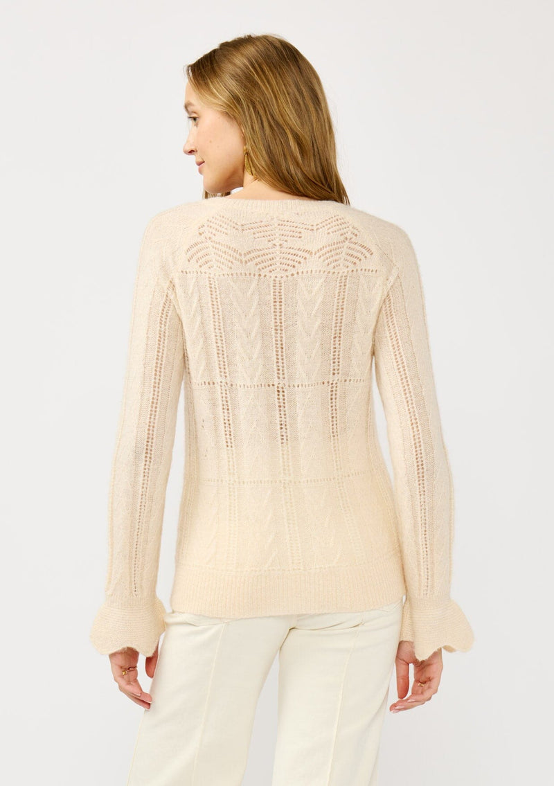 [Color: Blush] A back facing image of a blonde model wearing a fuzzy open knit pullover sweater with a crew neckline, long sleeves, and a flutter cuff. Lightweight and breezy for the fall season. 