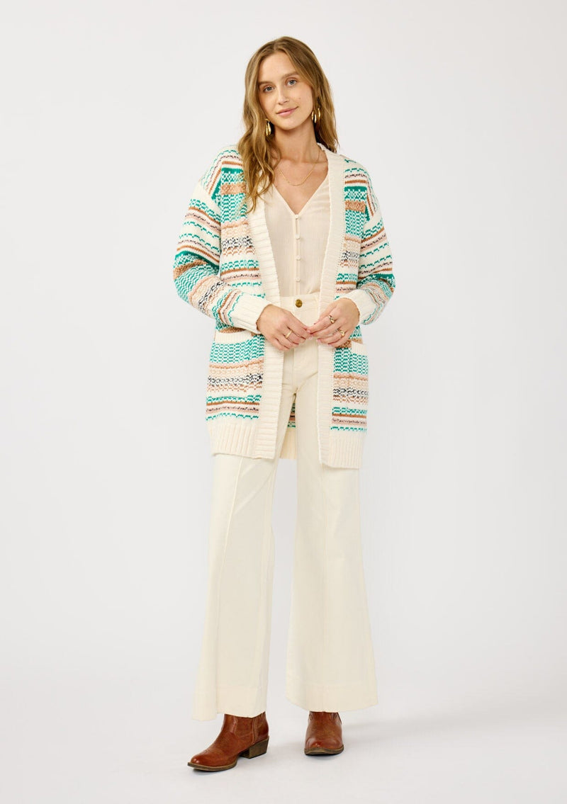 [Color: White/Green] A front facing image of a blonde model wearing a green and brown striped knit cardigan with a contrasting ribbed trim. Featuring long cozy sleeves and an open front for easy layering. A boho inspired cardigan for the fall season. 
