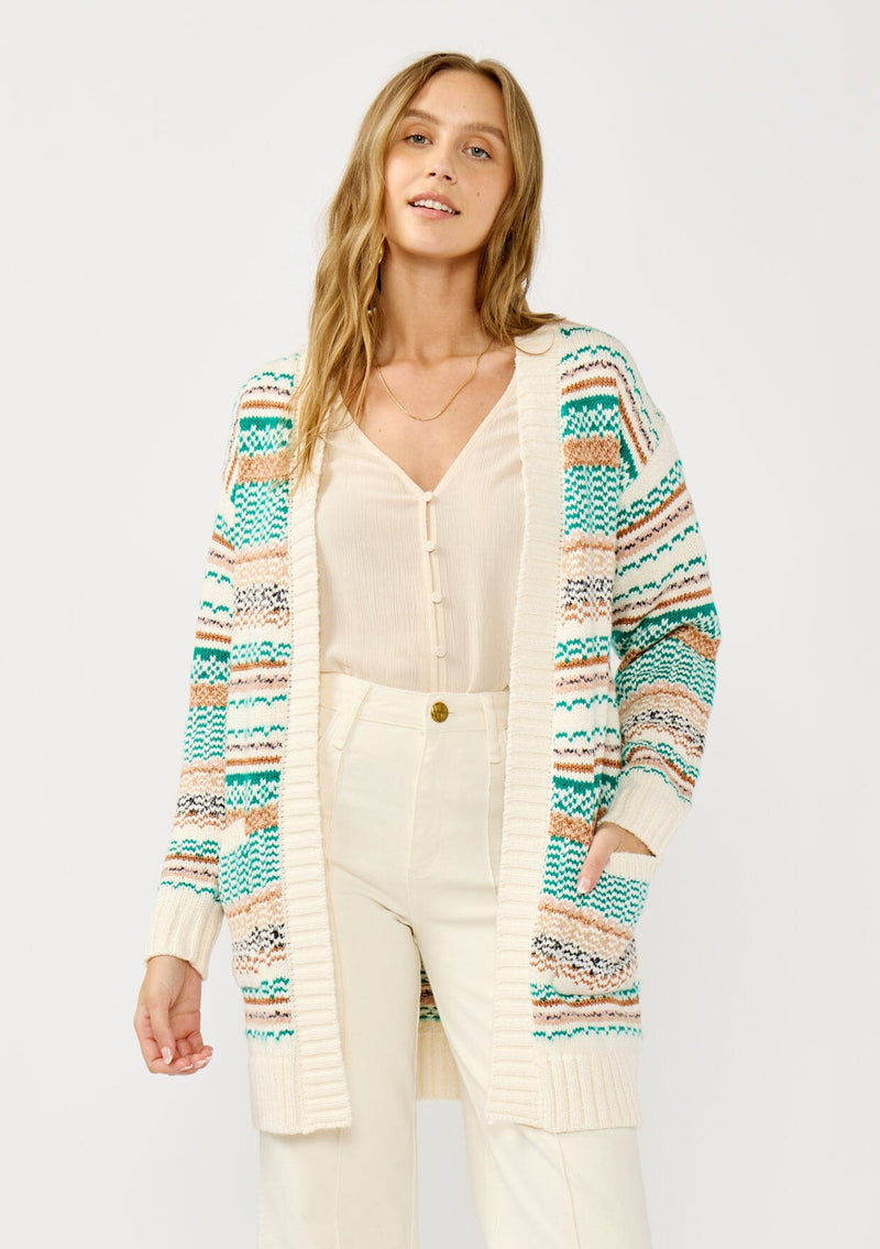 [Color: White/Green] A front facing image of a blonde model wearing a green and brown striped knit cardigan with a contrasting ribbed trim. Featuring long cozy sleeves and an open front for easy layering. A boho inspired cardigan for the fall season. 