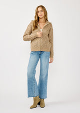 [Color: Mocha] A front facing image of a blonde model wearing a brown cable knit sweater with a full-zip front, funnel neck, and ribbed trims. A classic fall layer to pair with denim. 