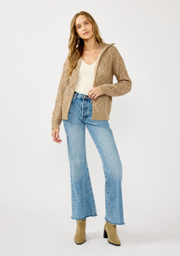 [Color: Mocha] A front facing image of a blonde model wearing a brown cable knit sweater with a full-zip front, funnel neck, and ribbed trims. A classic fall layer to pair with denim. 