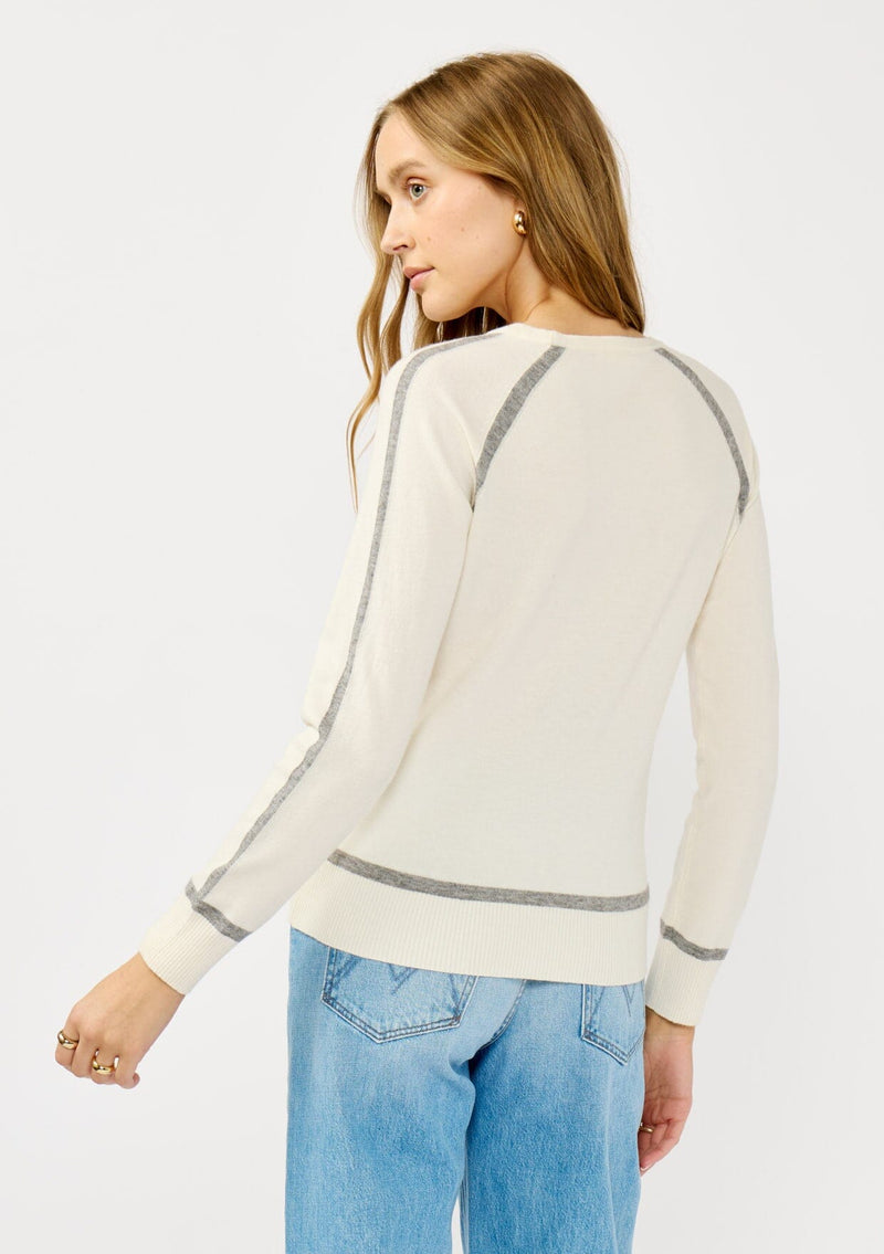 [Color: Cream/Heather Grey] A back facing image of a blonde model wearing a cream pullover sweater with a grey border stripe. Featuring long cozy sleeves, a classic crew neckline, and ribbed trimming. 