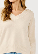 [Color: Heather Petal] A detail image of a blonde model wearing a classic cozy v-neck pullover sweater with ribbed trims. Perfect for casual outings and the office. 