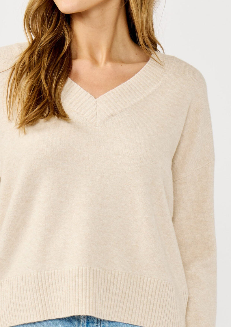 [Color: Heather Petal] A detail image of a blonde model wearing a classic cozy v-neck pullover sweater with ribbed trims. Perfect for casual outings and the office. 